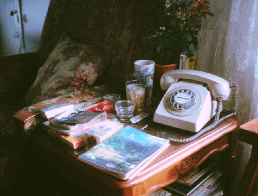 Rotary phone on a side table, nostalgic 1990s home setting